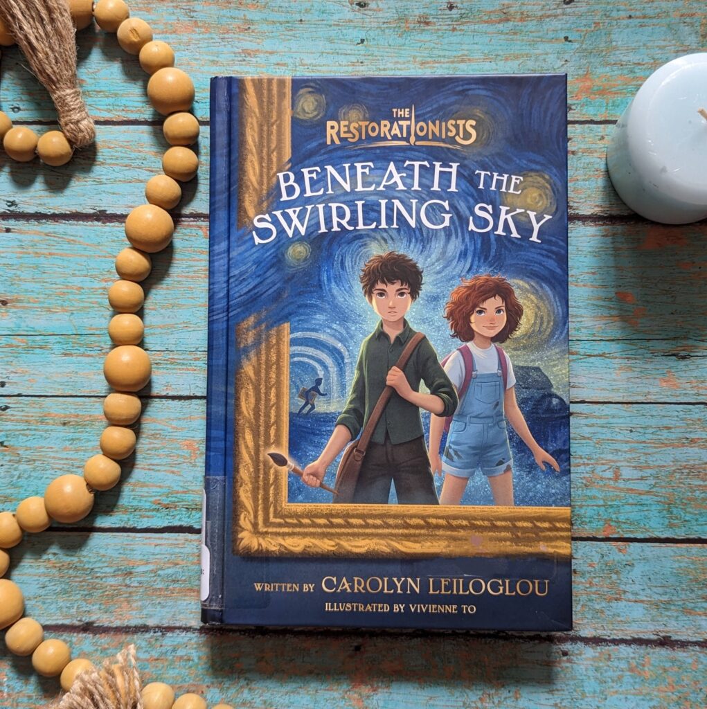 Beneath the Swirling Sky by Carolyn Leiloglou book sitting on turquoise wooden slats with wooden beads and blue candle next to it